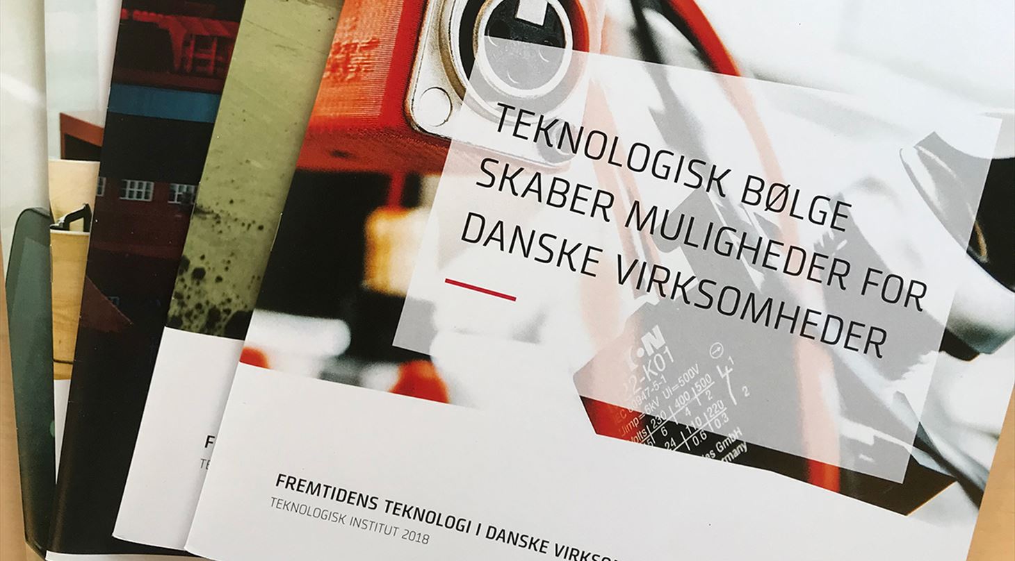 Et billede af en stak rapporter om teknologi i danske virksomheder.